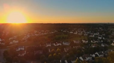 Gün batımında muhteşem pembe gökyüzü yaz mevsiminde küçük bir şehirde güzel bir yeşil köyde güzel bir stilin üzerinde.