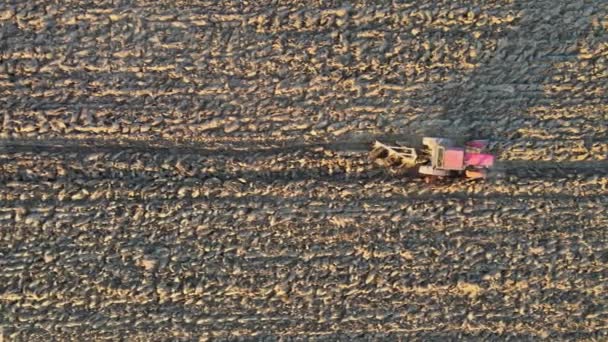 Luftaufnahme des landwirtschaftlichen Feldes moderner roter Traktor pflügt Land. — Stockvideo