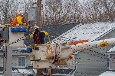 10 Şubat NYC NY ABD: Elektrik direğindeki takım çalışmacısı, kar yağışı sonrasında elektrik hattı için genişliyor