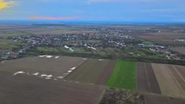 Sonbahar tarlalarının insansız hava görüntüsü, küçük köyün etrafındaki kırsal tarım arazileri.