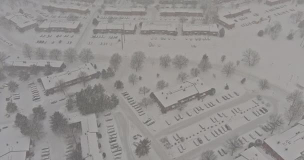 Sneeuw bedekt bomen in de storm wolken boven sneeuw over kleine stad residentiële met daken huizen in de VS — Stockvideo