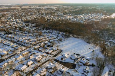 Karla kaplı küçük bir kasabada kar yağdıktan sonra Amerika 'nın kırsal kesimindeki kır manzaralı çatılarda evler.