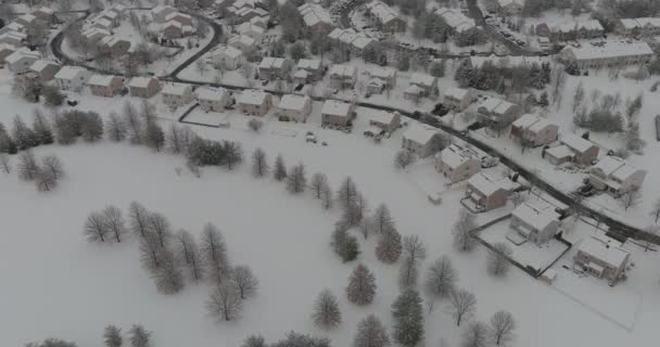 Maravilloso paisaje invernal casas cubiertas de nieve en la vista aérea con residencial pequeña ciudad nevada durante un invierno después de árboles de nieve cubiertos — Vídeos de Stock
