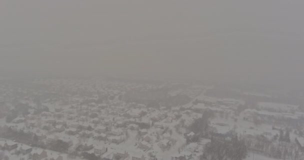 Зимний вид во время снегопада день крыши домов в маленьком городке снежный покрытый снег с жилыми небольшим городским пейзажем улицы — стоковое видео