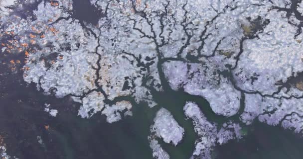 Jég sodródik az olvadó jég darabkáin a folyó partján a tavaszi nap alatt. — Stock videók