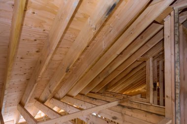 İnşaat halindeki ev odası. İnşaat için kiriş iskeletinin tamamlanmamış ahşap çatısı.