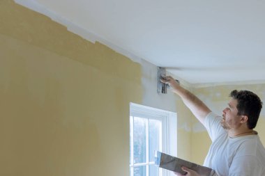 Bitirilmemiş duvar için sıva aracı kullanarak el aracı duvarını çalıştır