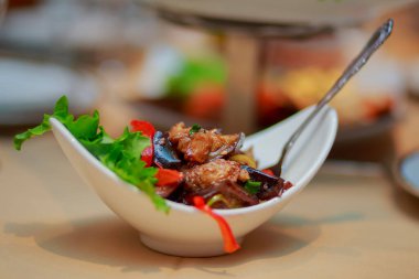 Patlıcan salatasının ahşap sırtı üzerinde sebze ve baharatla kızartılmış.