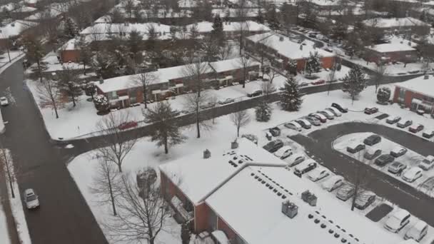 雪の降る冬の日に小さな町の住宅街のアパートの空中ビュー — ストック動画