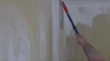 Duvarları astar boyayla boyamak bir evin beyaz renk tamiri üzerine