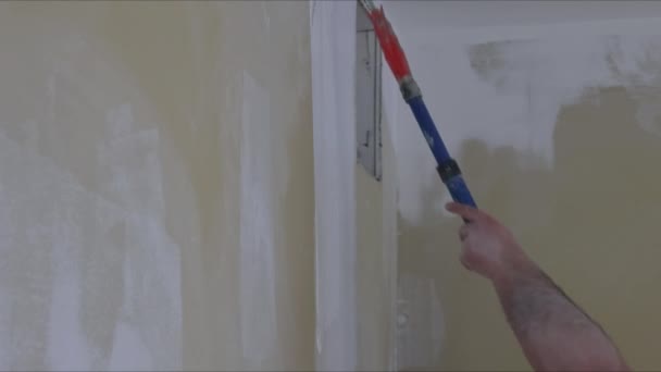 La pintura de las paredes en la imprimación sobre la reparación del color blanco en la casa — Vídeos de Stock