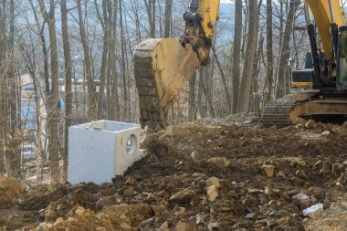 Ağır kazıcı, yol çalışmaları sırasında toprak kazıyor, yeni kalkınma yolunun inşası sırasında toprağı hareket ettiriyor..