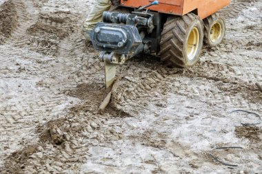 Ttractor yeraltı borularının döşemesini kazarken, bahçeye su püskürtücü yerleştirirken dünyayı izledi.