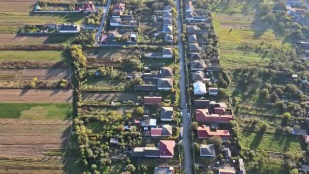 Bonito de vista aérea da altura da aldeia rural com casas e ruas, campos arados, prados — Vídeo de Stock