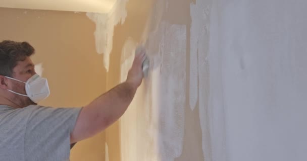 L'homme ponçant la plaque de plâtre de plâtre dans les cloisons sèches — Video