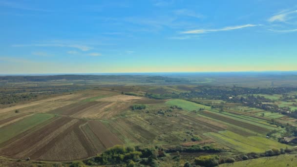 Campo agrícola de visão aérea na encosta em montanhas perto da aldeia — Vídeo de Stock