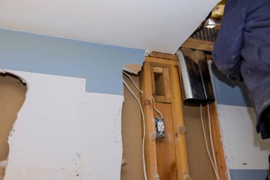 Tavanın üzerine monte ettiği ısıtma sistemi kanalları mutfaktaki havalandırma boru sisteminin iç tesisatı beyaz tavan duvarında..