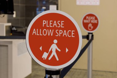 Havaalanı terminaline giriş yapmadan önce COVID-19 salgını için önleyici işaretler.