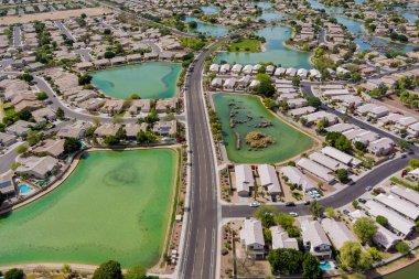 Avondale kasabası Arizona USA 'nın küçük göleti yakınlarındaki banliyö evleri üzerindeki tek aile panoramik manzara