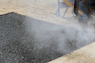Asfalt döşeyen yeni yol yüzeyi işçisi asfalt kaplamasını tamir ederken