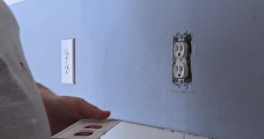 Boyanmaya hazırlanırken prizi maskelemek için duvar düğmesi kapağı kaldırılıyor
