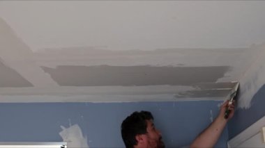 İşçi odasındaki tadilat sırasında duvarın tavanını sıva ile kaplamış.