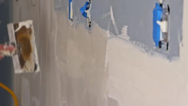 Homem alinhando uma parede com espátula trabalhando com massa de vidraceiro e espátula parede — Vídeo de Stock