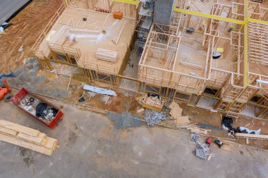 Büyük inşaat çöplerinin havadan görünüşü, inşaat halindeki yeni ev için istiflenmiş ahşap tahtalar ve kirişler üzerindeki çöplüğü reddediyor.