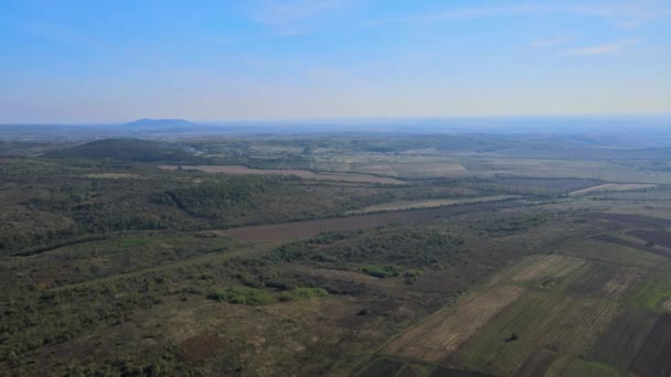 Flygfoto panorama i fält på sluttningen i bergen nära byn i underbart vårlandskap — Stockvideo