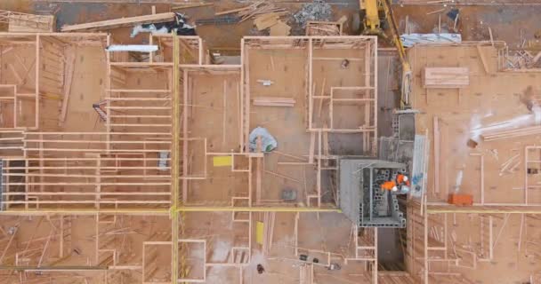 Widok z lotu ptaka szyb windy do budynku bloku betonowego w budowie na robotnikach układają bloki — Wideo stockowe