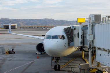 Bağlı biniş köprüsündeki terminal kapısındaki yolcu uçağı bagajlarla dolu.