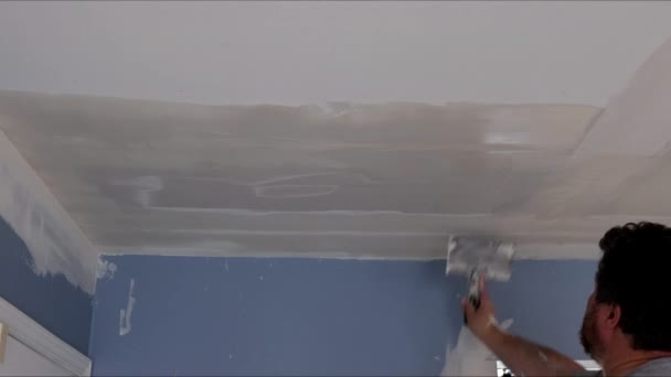 Stukadoor met stopverf op de muur met stopverf het plafond met een spatel — Stockvideo