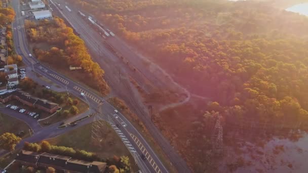 Autumn landscape aerial view of train on along beautiful railroad in fall trees, railway with road, residential a town areas — Stock Video