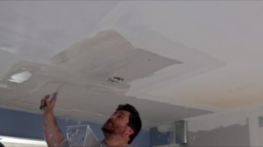 Odanın tavanına macun sürmeye devam et. Dairenin boyanması için tavana macun yapıştır.