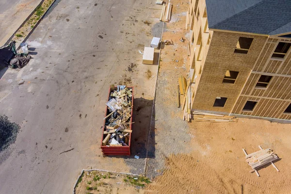 Aerial view of apartment framing of a new house under stacker wooden boards the trash dumpsters construction