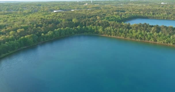 Luchtfoto panorama uitzicht op het groene bos tussen turquoise kleur meer — Stockvideo