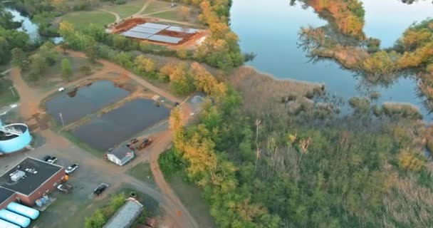 Vista aérea superior de los tanques de purificación de la planta de tratamiento de aguas residuales moderna un lago forestal — Vídeo de stock