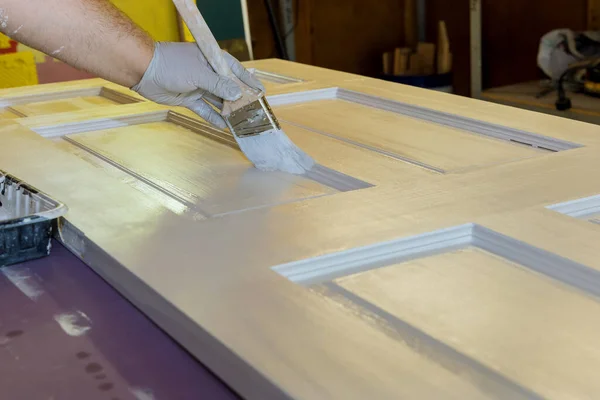 塗装ブラシを使用して木製のドアを塗装するための請負業者の木工マスタープロセス — ストック写真