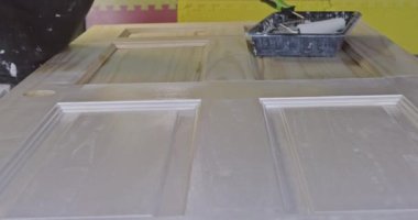 Tamirci ev boyacısı. Boyalı fırça boyası kullanarak kapı boyama ustası.