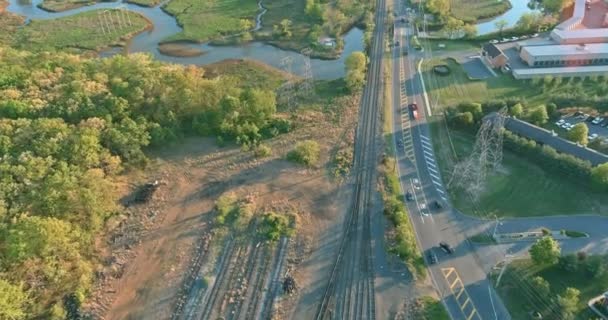 Vista aérea superior a locomotiva em trilhos perto da estrada as plataformas do cubo ferroviário — Vídeo de Stock