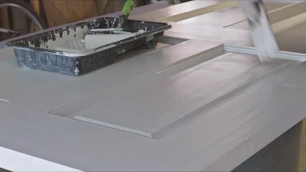 Il maestro appaltatore lavora la pittura per dipingere porte in legno con pennello — Video Stock