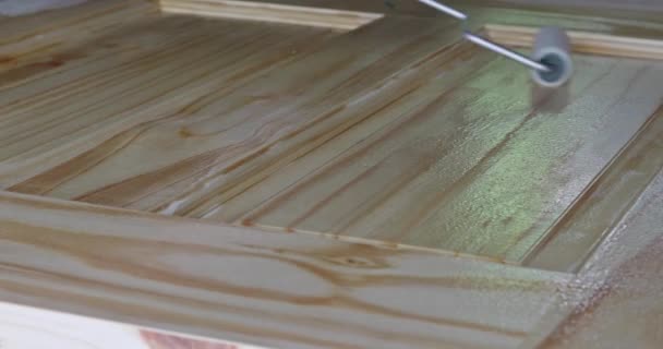 Aannemer schilder vernis voor het schilderen van nieuwe lijstwerk houten voordeur met behulp van verf borstel vernis met handschoenen — Stockvideo