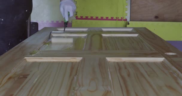 Arbetare hand håller en pensel målning nya trä formning trim med pensel — Stockvideo