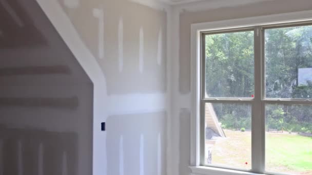 Plastering drywall new home industry on finishing putty in the room walls plasterboards with room under construction — Stock Video