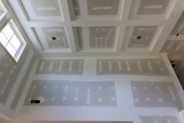 stock image Finishing putty on drywall with a spatula the house on ceiling and wall