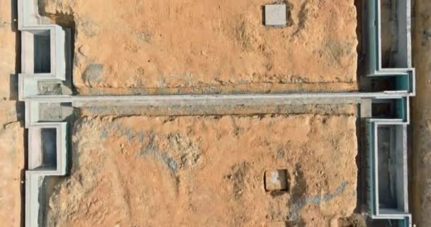 Lugar de construcción de trincheras excavadas en el suelo y llenas de cemento como base para la futura casa — Vídeos de Stock