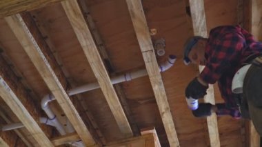 Tesisatçı plastik tuvalet beyaz borusunu yakın çekim için yapıştırıyor.