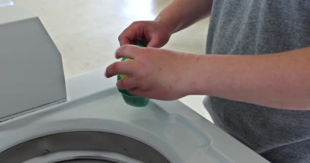 Femme de ménage verse la poudre liquide dans la machine à laver — Video