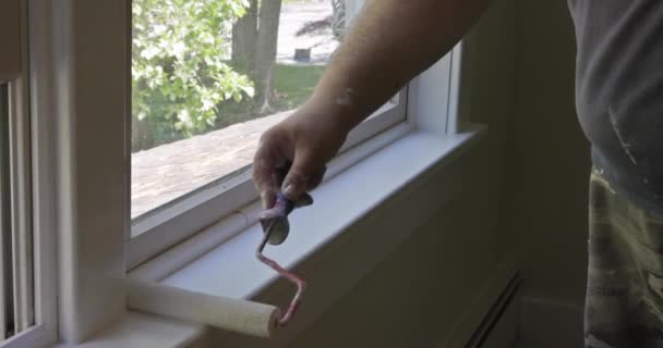 Peinture de travailleur à l'aide de rouleau de peinture sur couche de couleur blanche une garniture de cadre de fenêtre — Video