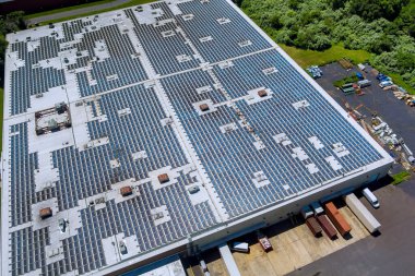 Fabrika çatısındaki güneş panelleri üzerindeki panoramik hava görüntüsü sürdürülebilir enerji üretmek için güneş ışığını emer.